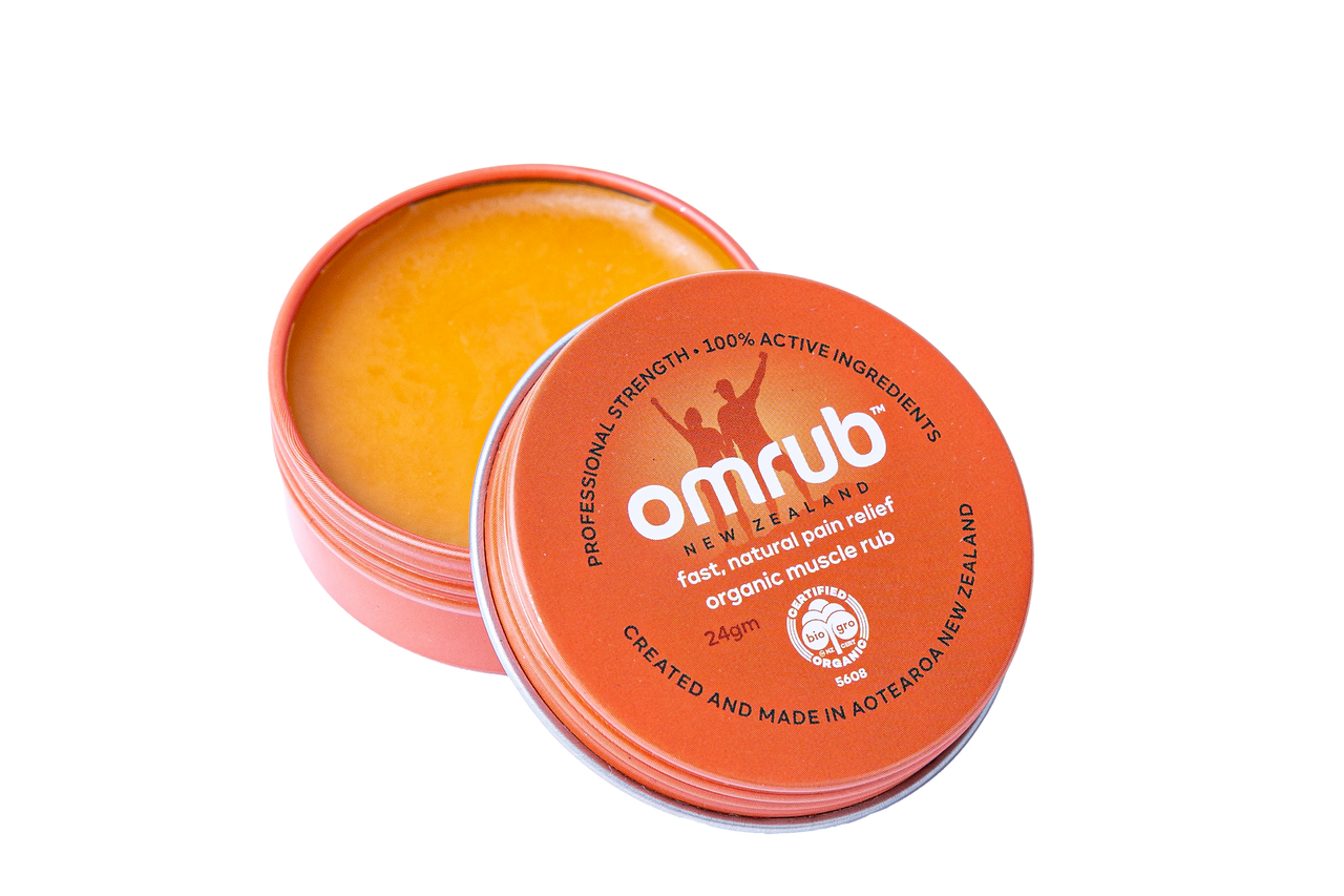 Open container of Omrub Organic Muscle Rub, an orange balm with 'omrub' branding on a white background